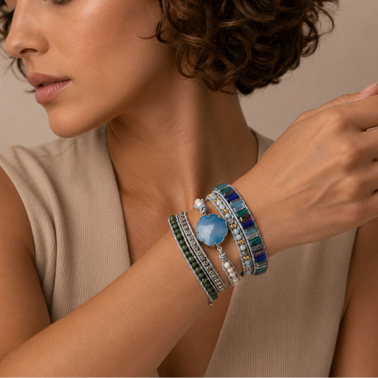 Woman wearing multiple colorful bracelets on her wrist against a neutral background