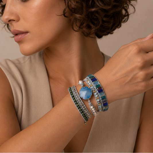 Woman wearing multiple colorful bracelets on her wrist against a neutral background