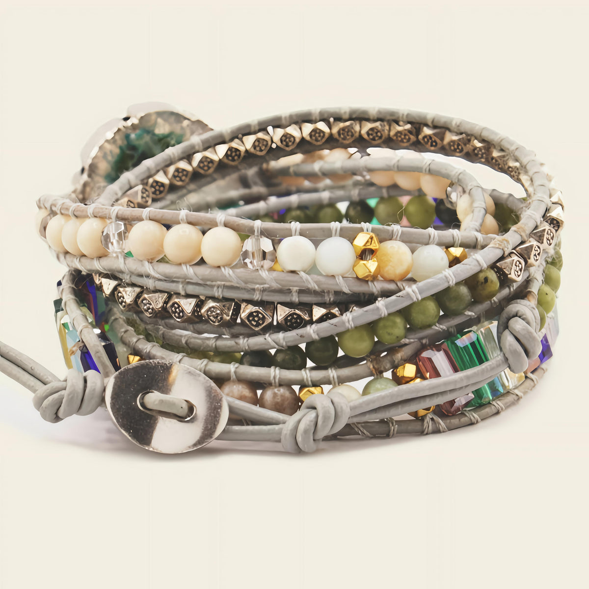 Multistrand beaded bracelet with gray leather strap on a light background