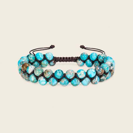 Turquoise beaded bracelet with black cord on a beige background