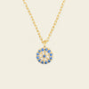 Gold necklace with a blue and white gemstone pendant on a beige background