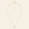 Gold necklace with a single pendant on a beige background