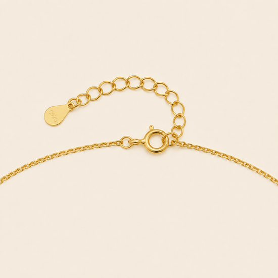 Gold chain bracelet on a beige background