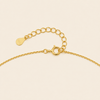 Gold chain bracelet on a beige background