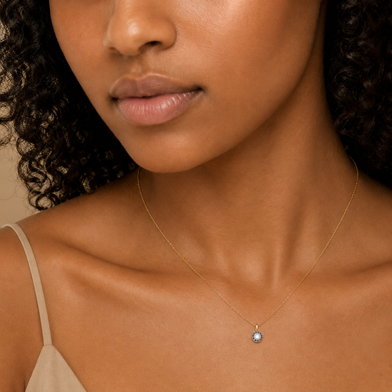 Close-up of a woman wearing a delicate necklace with a small pendant.