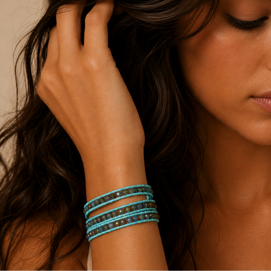 Close-up of a woman's hand wearing multiple bracelets with a neutral background