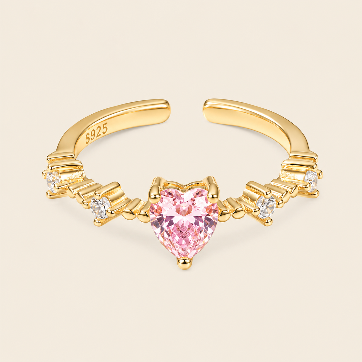 Gold nose ring with a pink heart-shaped gemstone on a beige background