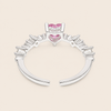 Silver ring with pink heart-shaped gemstones on a beige background