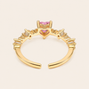 Gold ring with pink gemstones on a beige background