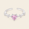 Silver nose ring with a heart-shaped pink gemstone on a beige background