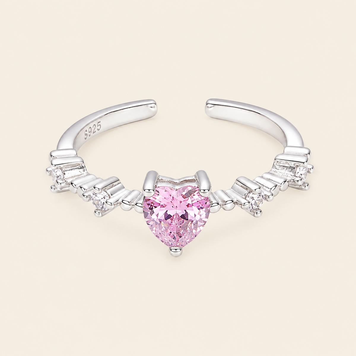 Silver nose ring with a heart-shaped pink gemstone on a beige background