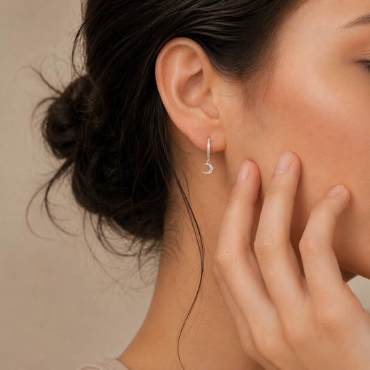 Close-up of a woman wearing a silver earring with a moon design.