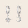 Silver hoop earrings with star and moon charms on a beige background