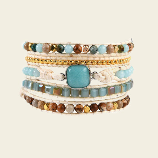 Stack of multicolored beaded bracelets on a beige background