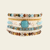 Stack of multicolored beaded bracelets on a beige background