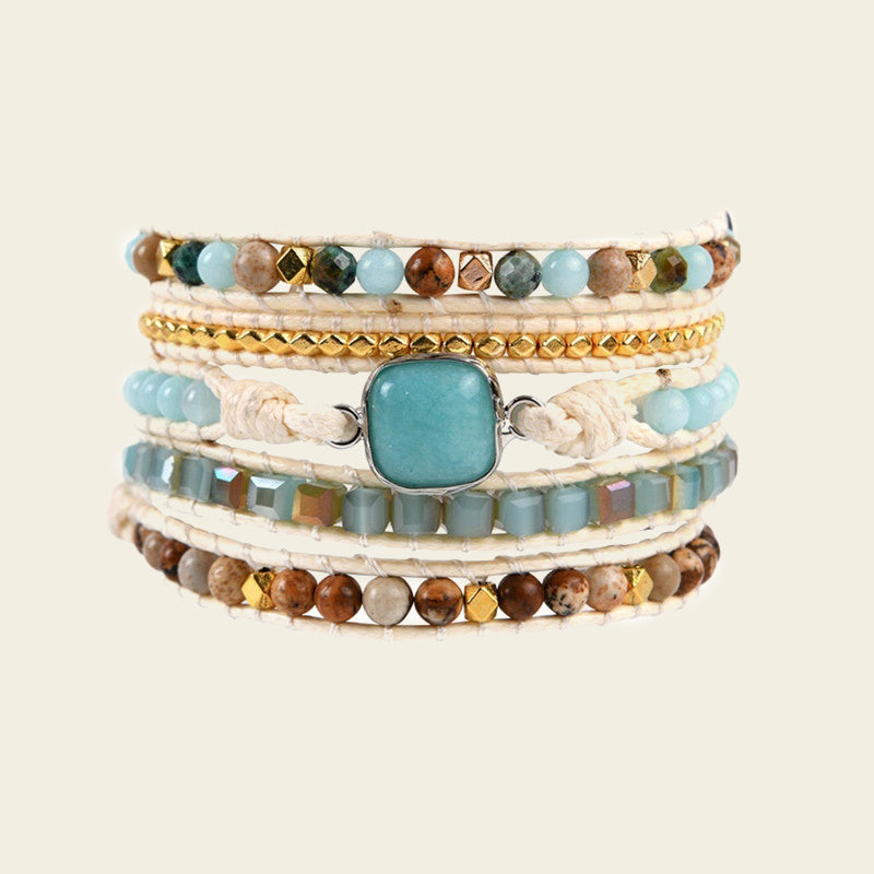 Stack of multicolored beaded bracelets on a beige background