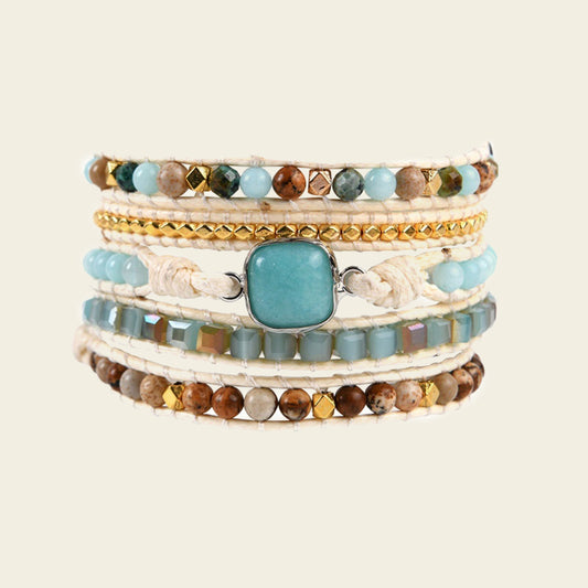 Stack of multicolored beaded bracelets on a beige background