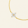 Gold necklace with a diamond pendant on a beige background