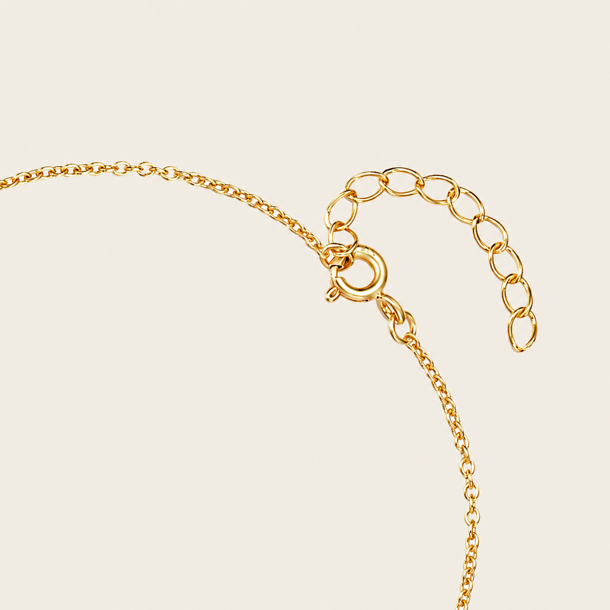 Gold chain bracelet on a beige background