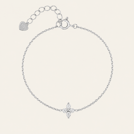 A delicate silver chain bracelet with a small star-shaped crystal charm at the bottom center, featuring an adjustable clasp with a heart-shaped tag engraved with 'LOVE'.