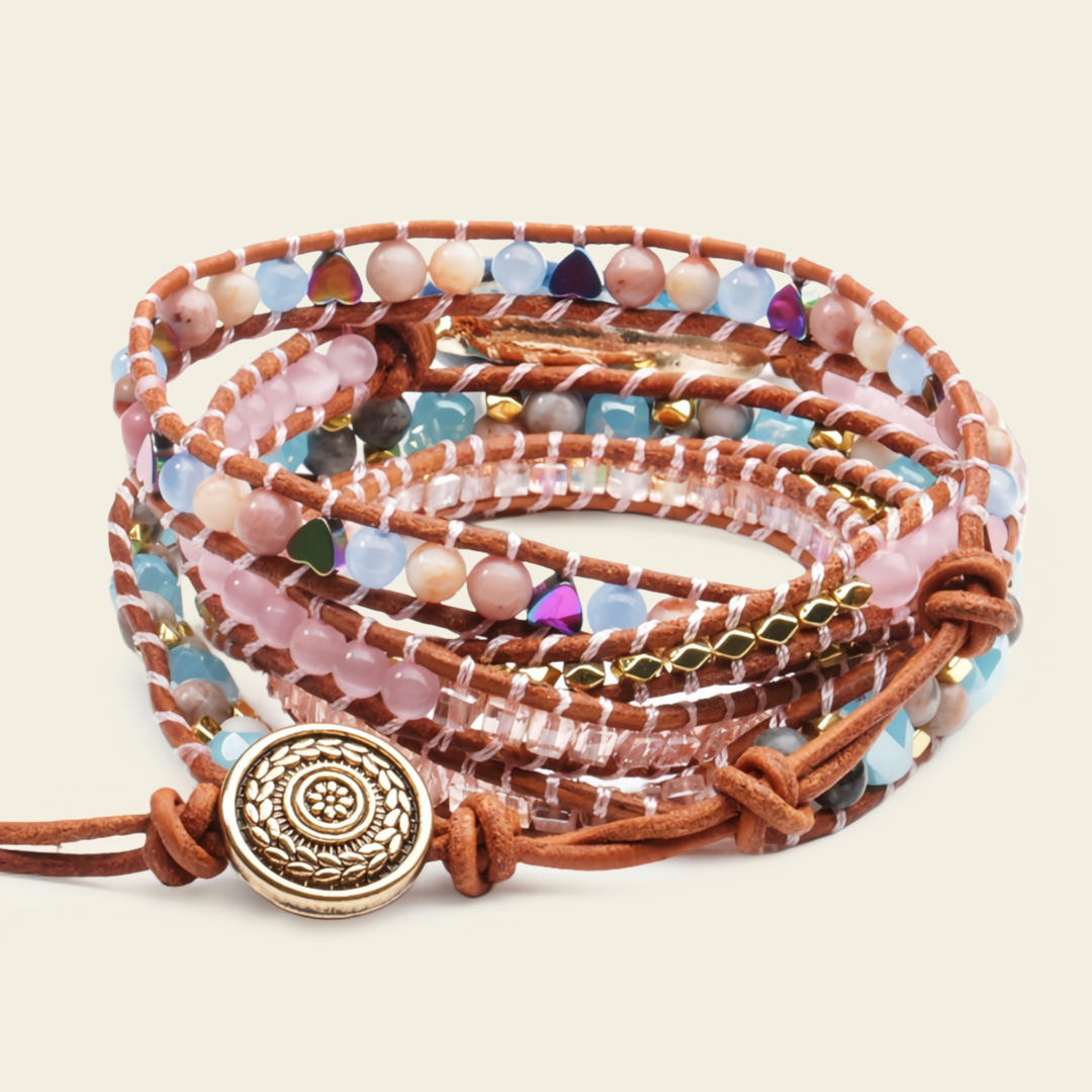A bohemian-style multi-strand wrap bracelet featuring brown leather cords, colorful faceted beads in pink, blue, green, and purple, and a prominent round gold-toned metal charm with an engraved sun design.