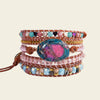Multicolored beaded bracelet with a central stone on a beige background
