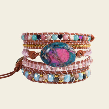 Multicolored beaded bracelet with a central stone on a beige background