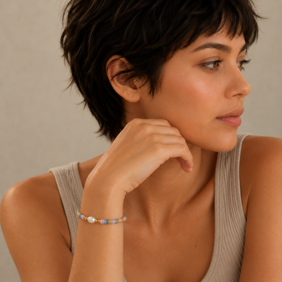 Woman wearing a colorful bracelet on a neutral background