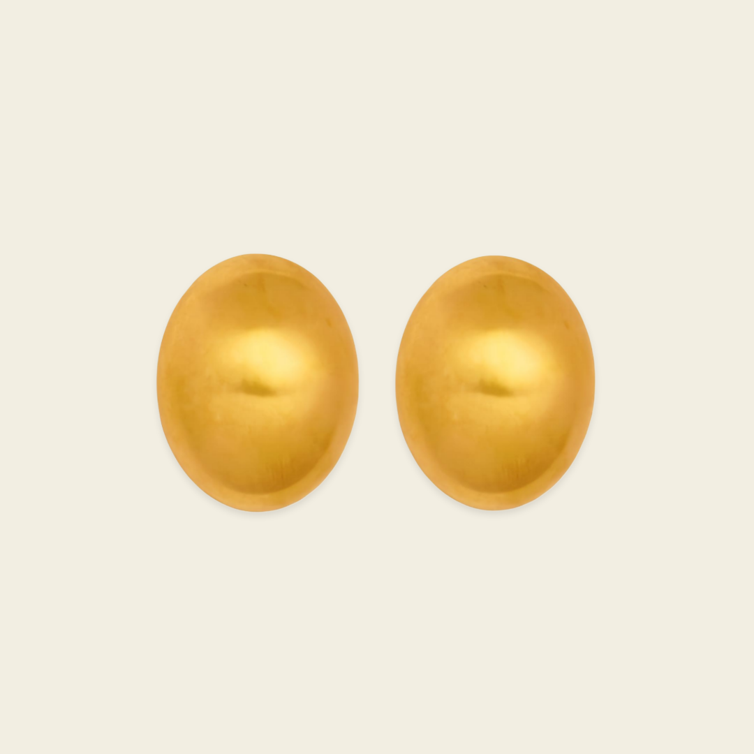 A pair of oval gold-toned stud earrings shown on a plain light beige background.