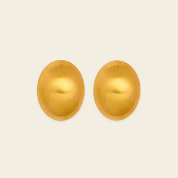 A pair of oval gold-toned stud earrings shown on a plain light beige background.