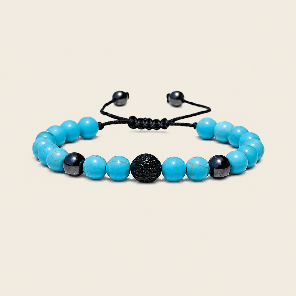 A beaded stretch bracelet featuring bright turquoise-blue beads, black marbled beads, and a central textured black sphere, strung on a black adjustable cord with black metal slider ends, set against a solid light beige background.