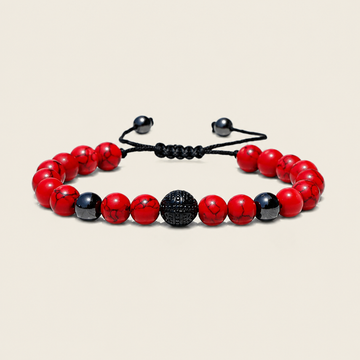 A beaded stretch bracelet featuring red and black marbled beads, a textured black central bead, and a black adjustable cord closure, displayed on a light beige background.