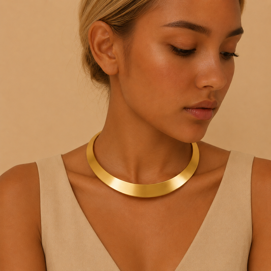 Woman wearing a gold necklace against a beige background
