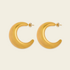 A pair of gold crescent-shaped hoop earrings with post backs, displayed on a light cream background.