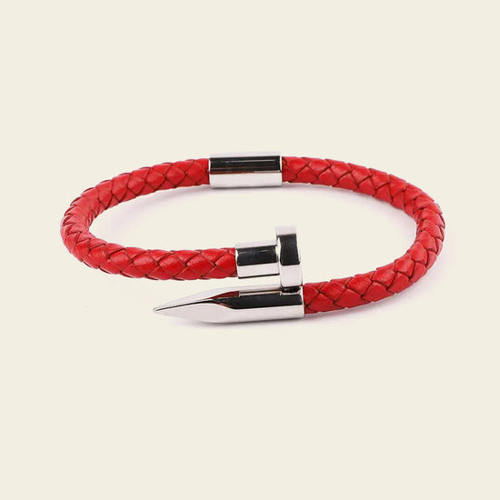 Red braided leather bracelet with silver clasp on a beige background