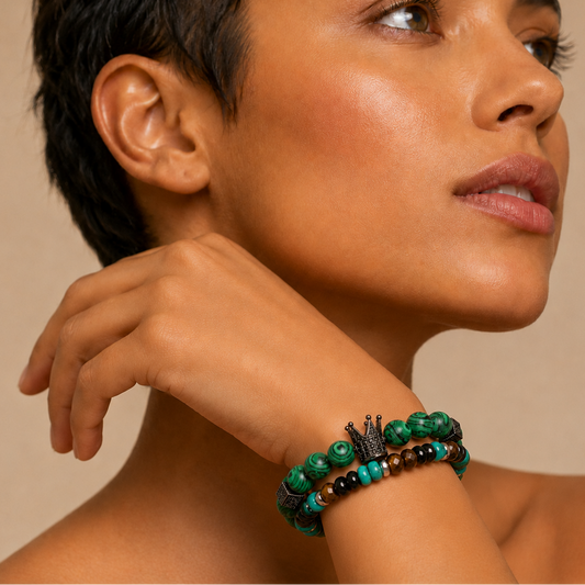 Woman wearing a green and black beaded bracelet on a beige background