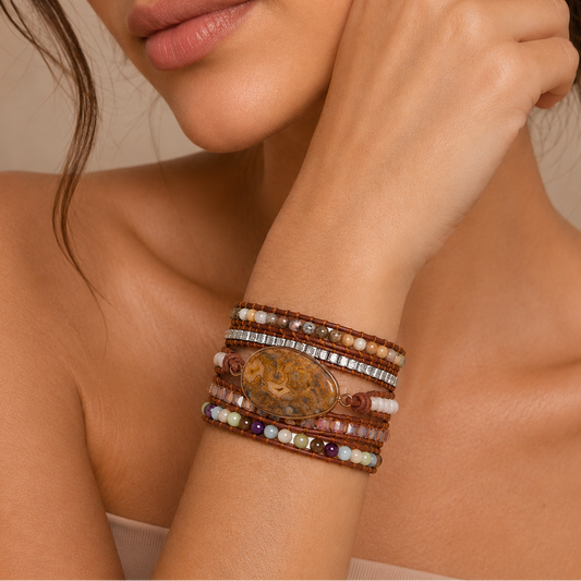 Close-up of a woman's arm wearing multiple bracelets with a neutral background