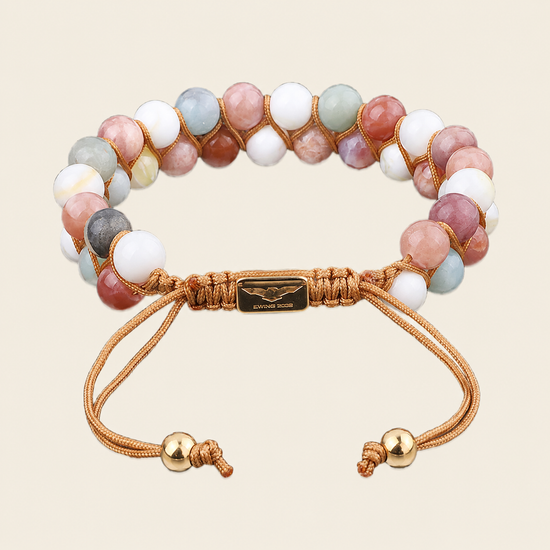Multicolored beaded bracelet with gold accents on a beige background