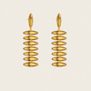 A pair of gold drop earrings with a stacked, ribbed disc design, shown against a solid light beige background.