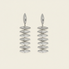 A pair of silver drop earrings with a series of horizontally oriented, polished oval discs hanging from a single elongated teardrop-shaped stud, set against a solid light cream background.