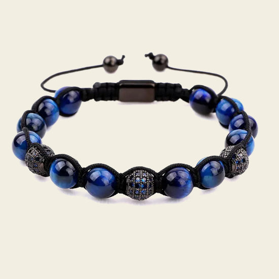 Blue beaded bracelet with black accents on a beige background