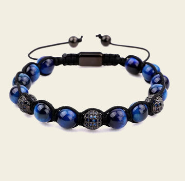 Blue beaded bracelet with black accents on a beige background