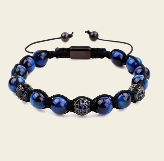 Blue beaded bracelet with black accents on a beige background