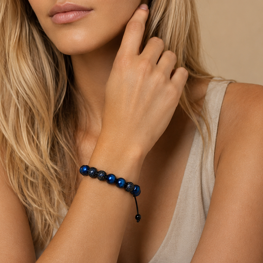 Close-up of a woman wearing a blue beaded bracelet on a beige background