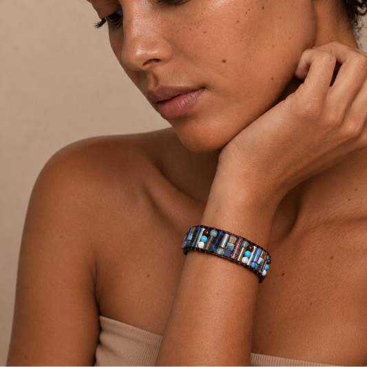 Woman wearing a colorful beaded bracelet on a beige background