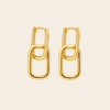A pair of gold chain-link hoop earrings on a light beige background.