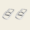 A pair of polished silver-toned interlocking oval link earrings on a solid light beige background.