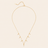 Gold necklace with small pendants on a beige background