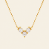 Gold necklace with a V-shaped diamond pendant on a beige background