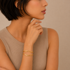 Woman wearing an Edge cuff with a plain background.